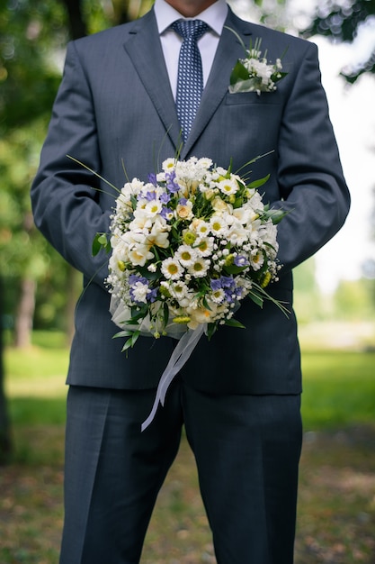 Huwelijksboeket in de handen van de bruidegom