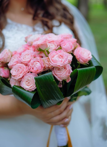 Huwelijksboeket met roze rozen in bruidhand