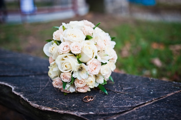 Huwelijksboeket van rozen met ringen op houten bank