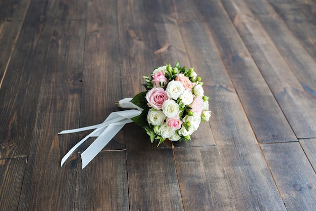 Foto huwelijksboeket van rozen op een houten close-up als achtergrond met een vrije plaats voor een inschrijving