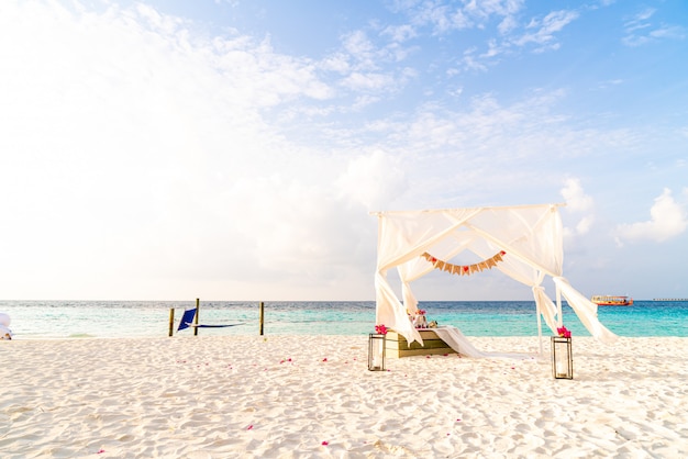 huwelijksboog op strand met tropische Maldiven resort en zee