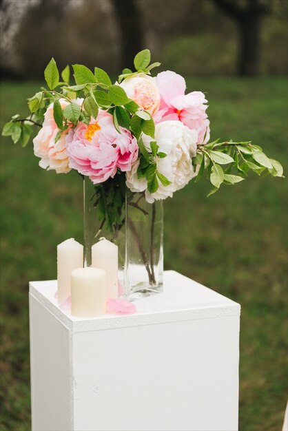 Huwelijksboog versierd met doek en bloemen buitenshuis