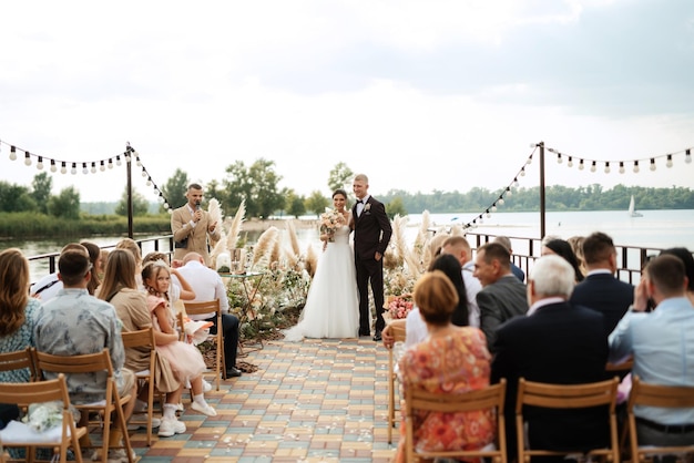 Huwelijksceremonie op een hoge pier bij de rivier