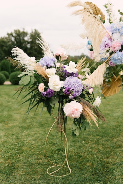 Huwelijksdecoraties Mooie ronde bloemenboog met hortensia en pampagras buiten huwelijksceremonie in de natuur