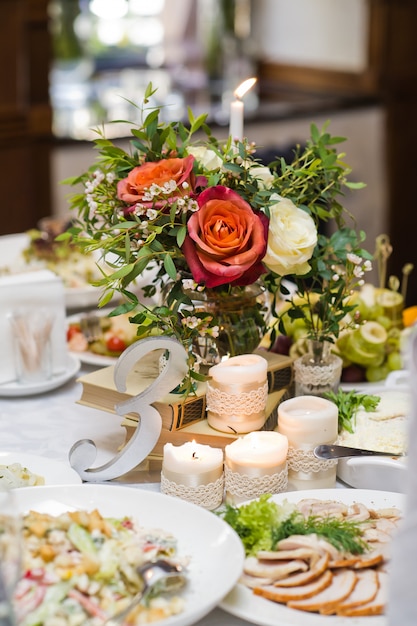 Huwelijksdiner in het restaurant, tafels versierd met vazen met rozen.