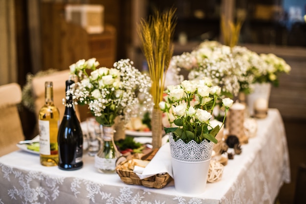 Huwelijkslijst in het restaurant met bloemen in rustieke stijl wordt verfraaid die