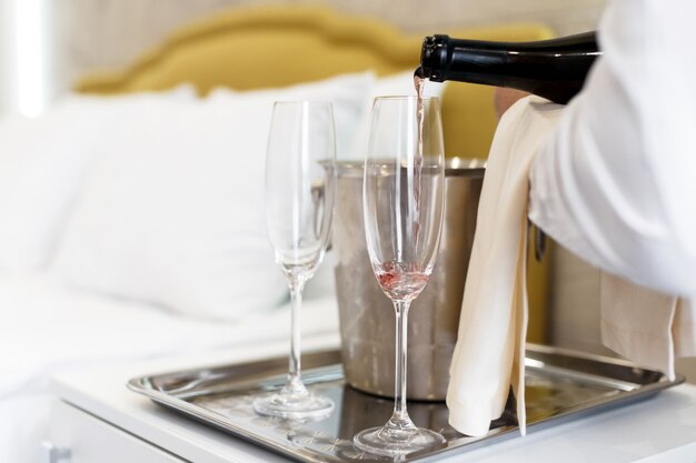 Huwelijksreis concept. Champagne-emmer dichtbij bed in een hotelruimte