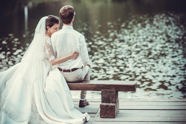 Huwelijksreis De bruid en bruidegom knuffelen aan de oever van Lake