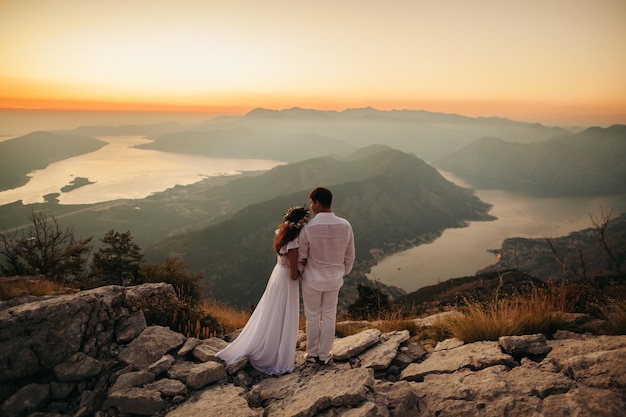 Huwelijksreis paar reizen bergen en uitzicht op zee. Zonsondergang in schilderachtige bergen. Kotor-baai, Montenegro.