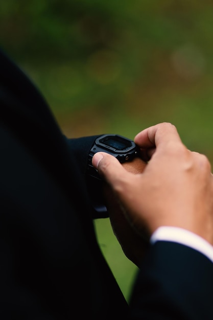 Huwelijksvoorbereidingen herenhorloge in de hand kleren opruimen voor de ceremonie