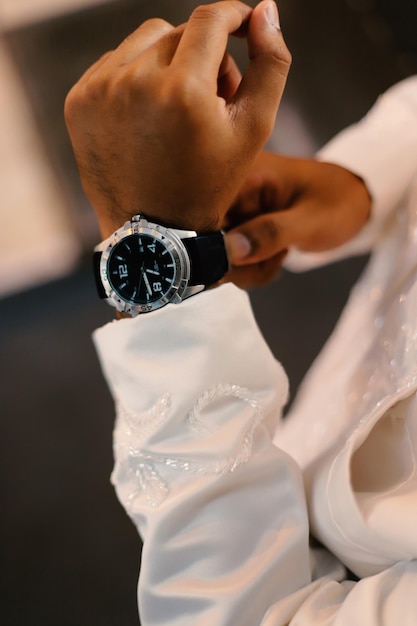 Huwelijksvoorbereidingen herenhorloge in de hand kleren opruimen voor de ceremonie