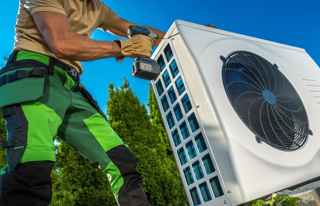 Hvac technician installing large modern heat pump