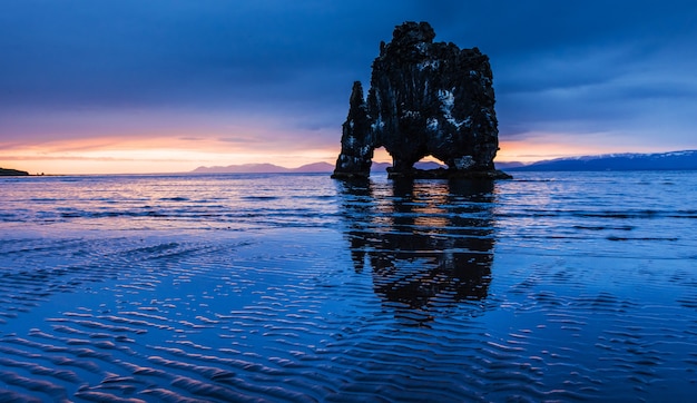 Hvitserkur高さ15 m。アイスランドの北海岸の海の壮観な岩です。この写真は、真夜中の日没後の水に反映されます。