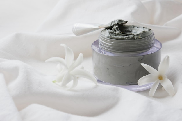 Hyacinth flowers and blue clay in a jar on a white cloth copy space