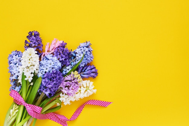 黄色の背景にヒヤシンスの花の花束