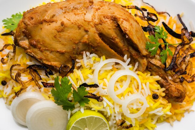 Hyderabadi chicken or dum biryani, served in a Kadhai or bowl with yogurt dip . selective focus