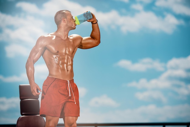 Hydratatie is belangrijk Atletische mannen drinken water na een training op een hete zomerdag