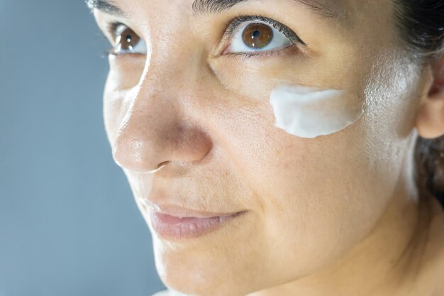 Foto hydratatie met crème schoonheid close-up portret van jonge vrouw met een gezonde gloeiende huid