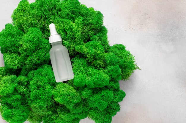 hydraterend serum in matte fles op groen mos