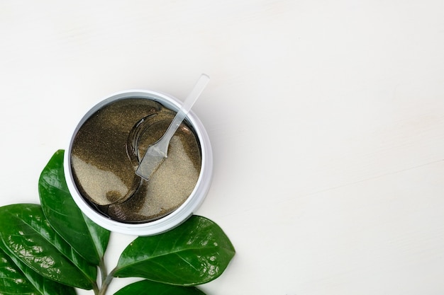 Hydrogel eye patches and green branch with leaves