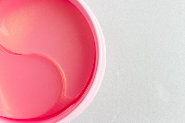 Hydrogel pink cosmetic eye patches in a jar. close-up photo, top view