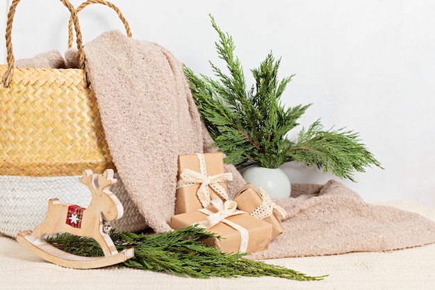 Hygge eco friendly paper wrapped presents with basket and warm soft blanket. Scandinavian Christmas zero waste decorations and gifts