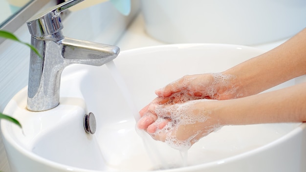 Concetto di igiene lavarsi le mani con il sapone nel lavandino per la prevenzione del covid19