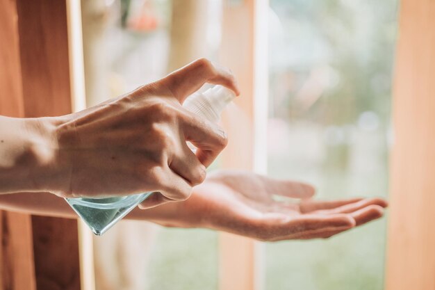 Hygiëne, gezondheidszorg en veiligheidsconcept - close-up van een vrouw die antibacteriële handzuiger spuit