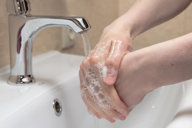 Foto hygiëne handen schoonmaken handen wassen met zeep vrouwen handen met schuim bescherm jezelf