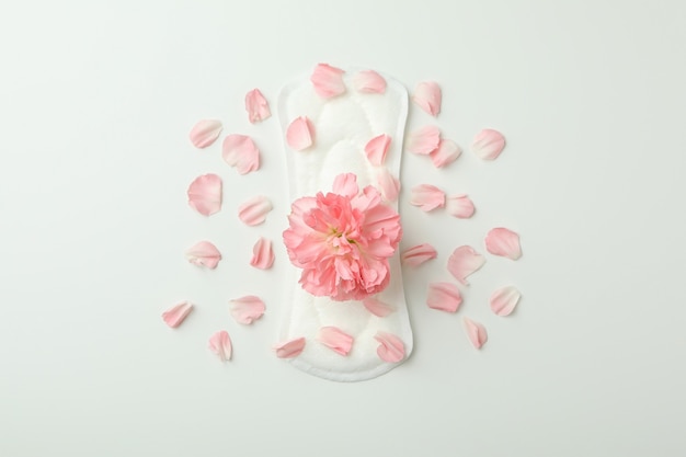 Photo hygiene pad with flower and petals on white background