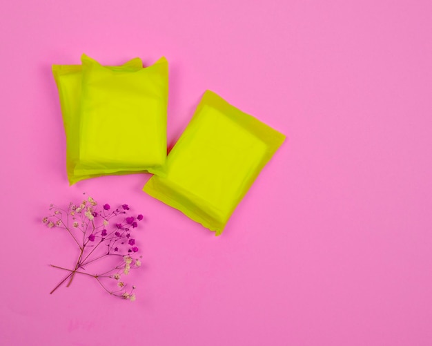 Hygiene products for women sanitary pads on a pink background\
view from above