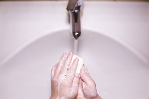 Foto norme igieniche. lavarsi le mani prima dei pasti. trattamento antibatterico delle mani con sapone. un modo per prevenire l'infezione da virus. protezione dal coronavirus.