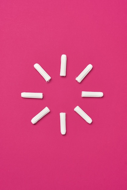 Фото Гигиенические женские тампоны для менструации на фоне розовой фуксии