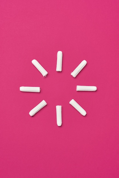 Hygienic feminine tampons for menstruation on a pink fuchsia background