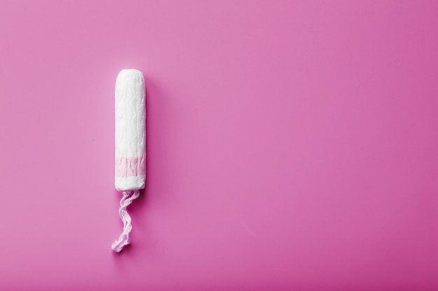 Hygienic tampon on a pink background with a free space