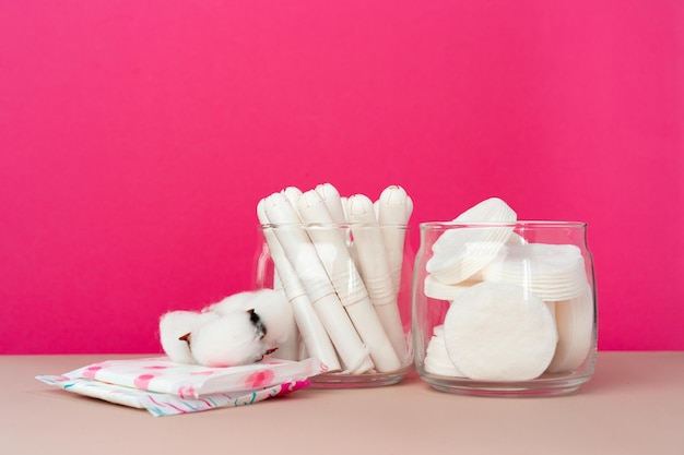 Hygienic tampons and cotton flower on paper background