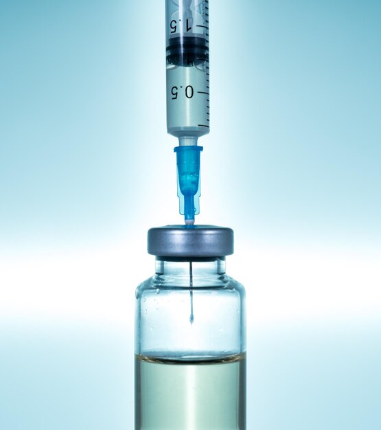 Hypodermic syringe needle inserted into a vaccine ampoule or bottle