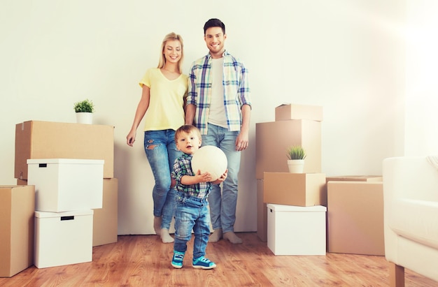 hypotheek, mensen, huisvesting, verhuizen en onroerend goed concept - gelukkig gezin met dozen ballen spelen in het nieuwe huis