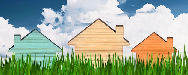 Hypotheek voor de aankoop van een huis. Verhuur onroerend goed. Veelkleurige houten huizen in het gras agai