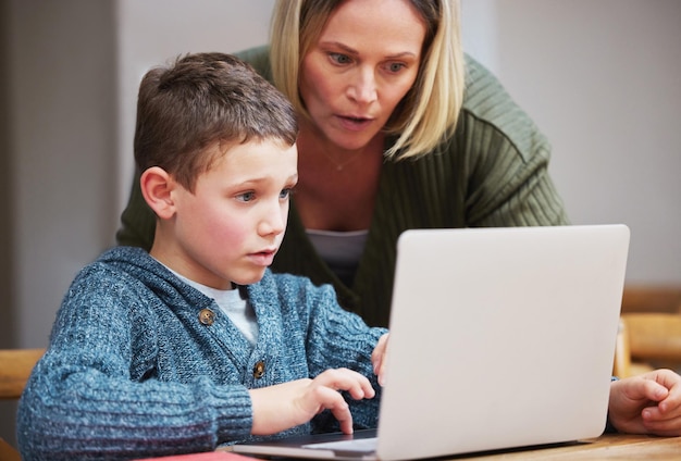 私はあなたを信じていますラップトップを使用して息子が宿題を完了するのを手伝っている母親のショット