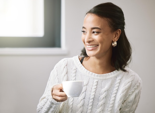 I can finally say I made it Shot of an attractive young woman sitting alone in her new home and enjoying a cup of tea