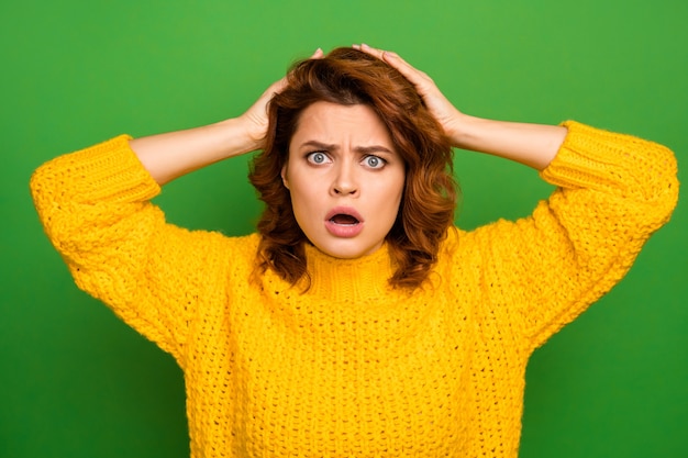 Photo i cant do that! frustrated shocked nervous woman hear unbelievable news her work mistake puzzled touch hands head scream wear good look knitted sweater isolated green color wall