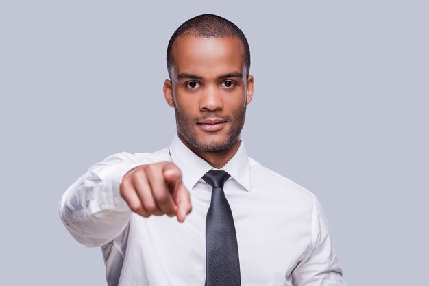 I choose you. Confident young African man in shirt and tie pointing you 