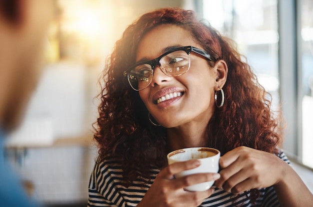 私は一日中コーヒーについて話すことができましたカフェで彼女のボーイフレンドとコーヒーを飲んでいる若い女性のショット