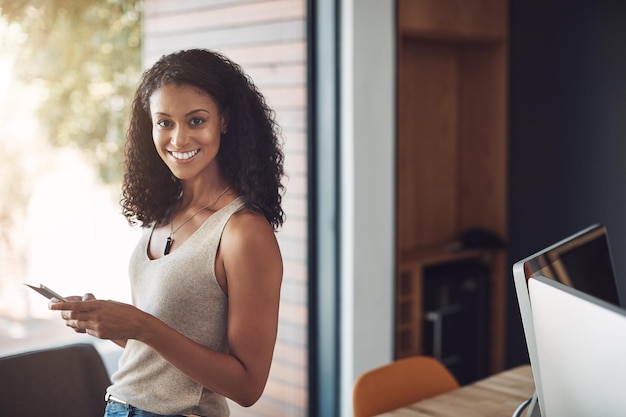 I couldnt imagine a workday without it. Portrait of an attractive young woman using a digital tablet in a modern office.