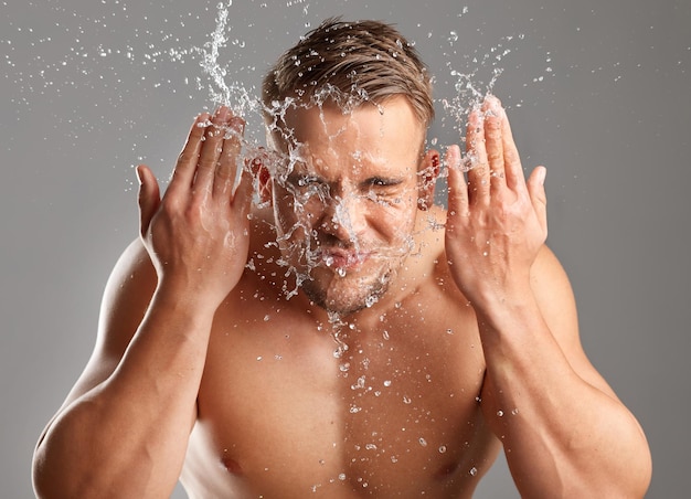 I dont have time for oil and grime Studio shot of a handsome young man washing his face against a grey background