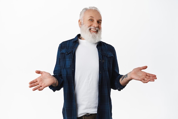 I dont know Handsome old man laughing and shrugging shoulders clueless cant tell anything have no idea standing confused and unaware against white background