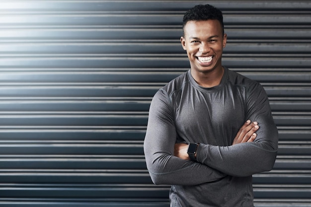 I earned results through strong determination Portrait of a sporty young man standing with his arms crossed against a grey background