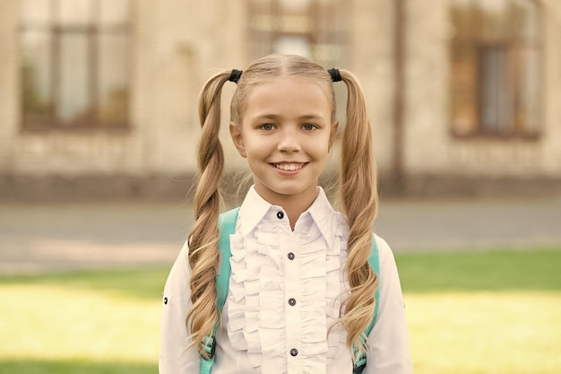 I got new rules first day of school happy schoolgirl urban\
background little schoolgirl back to school small schoolgirl wear\
formal uniform charming look of cute schoolgirl school and\
eduction