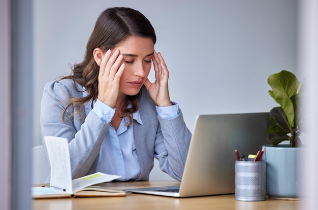 I just need some space to breathe Shot of a businesswoman experiencing a headache at work